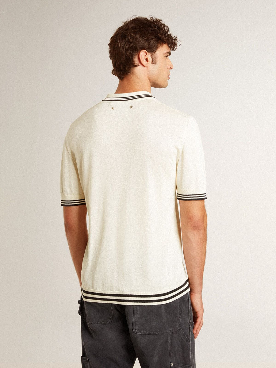 abgetragenes weißes strickpoloshirt für herren mit blauen rippstrickbündchen