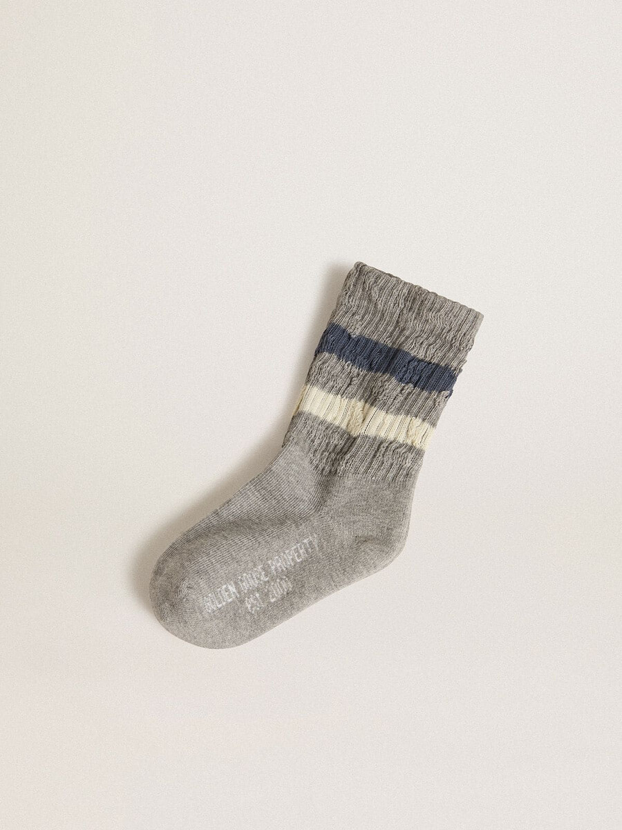 graue kindersocken mit used-look-details und abgenutzten weißen und blauen streifen