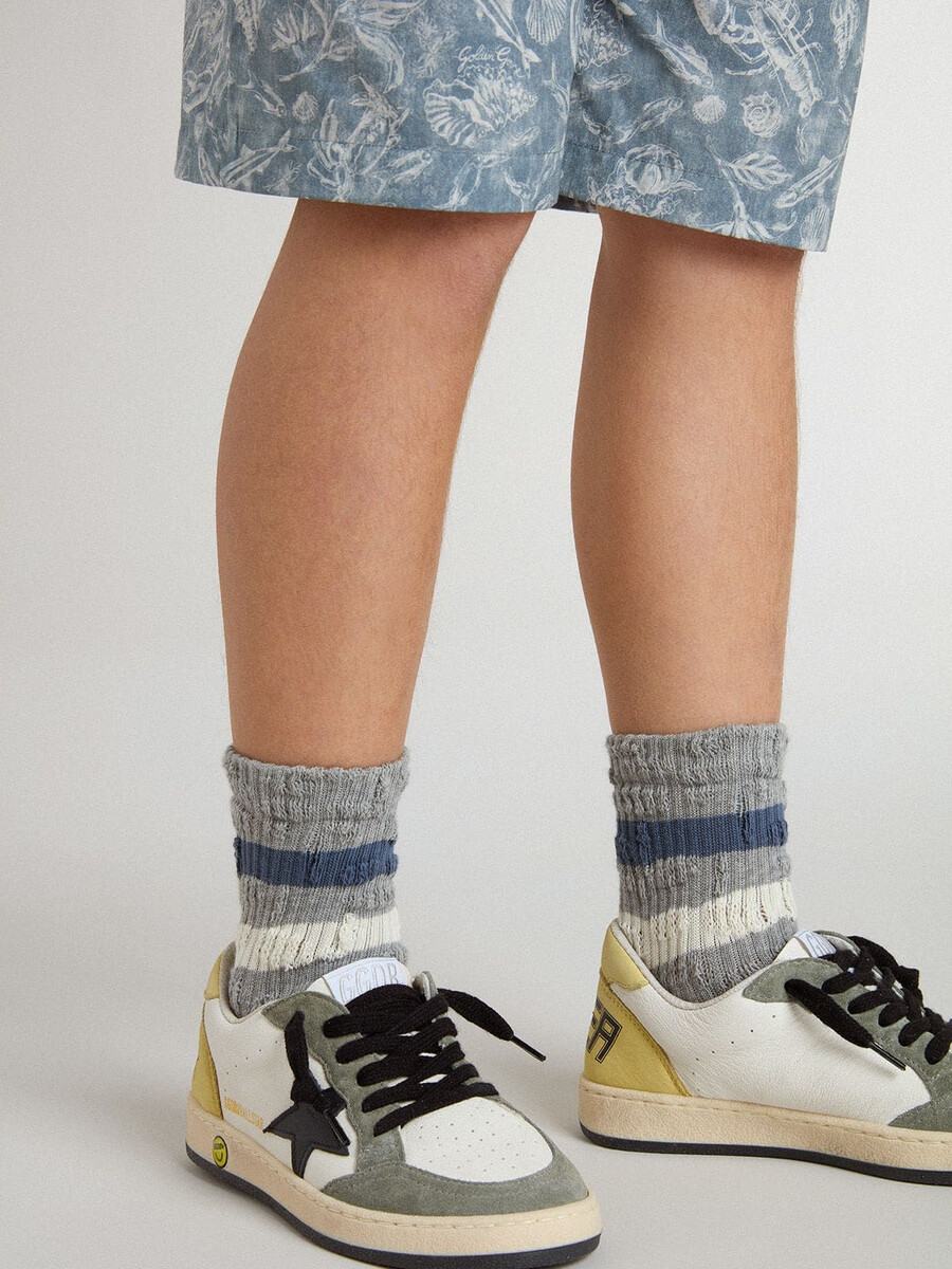graue kindersocken mit used-look-details und abgenutzten weißen und blauen streifen