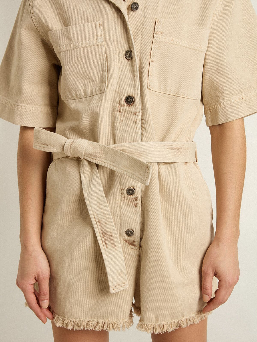 damen-jumpsuit aus beigefarbenem denim mit gürtel und ausgefranstem saum