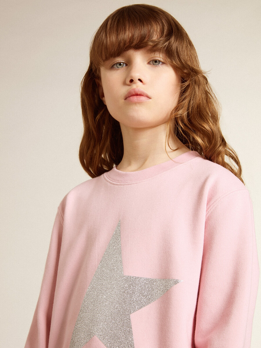 rosa sweatshirt mit großem silbernen glitzerstern auf der vorderseite