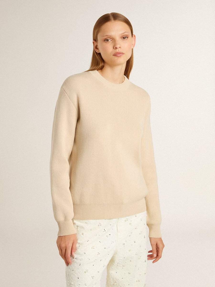 beigefarbener damenpullover mit dem schriftzug „golden auf dem rücken