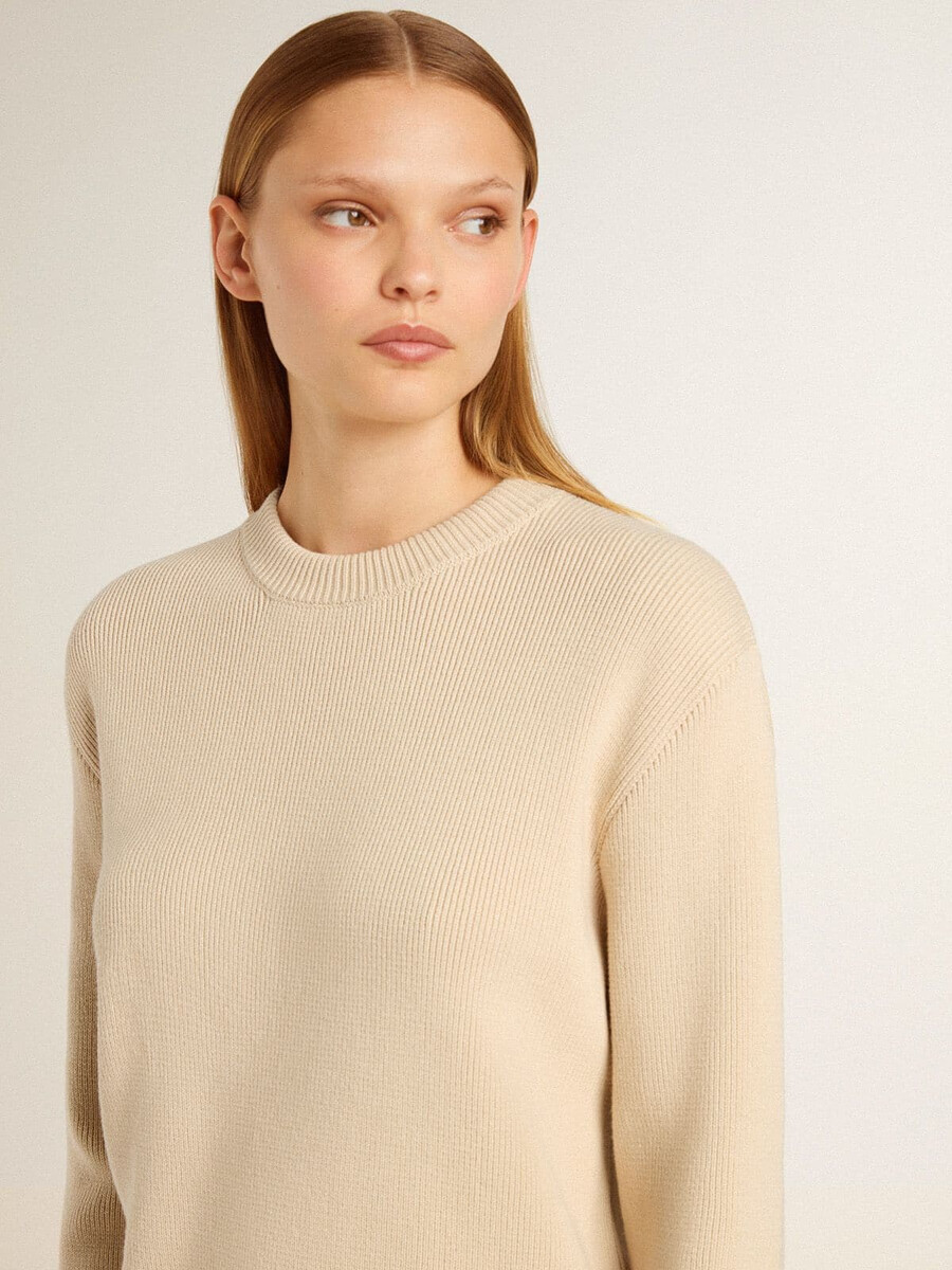 beigefarbener damenpullover mit dem schriftzug „golden auf dem rücken