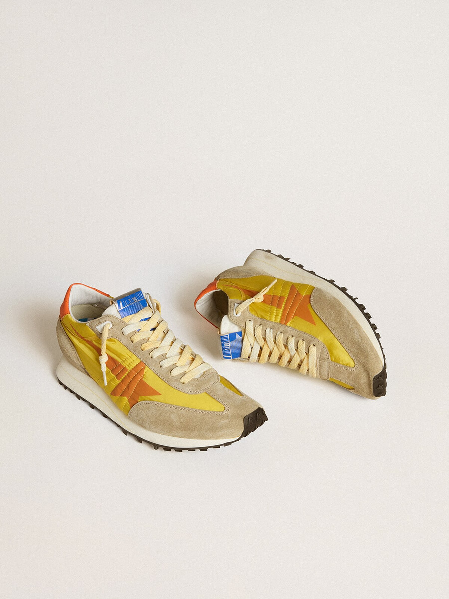 herren-marathonschuh mit gelbem nylon-obermaterial und orangefarbenem stern