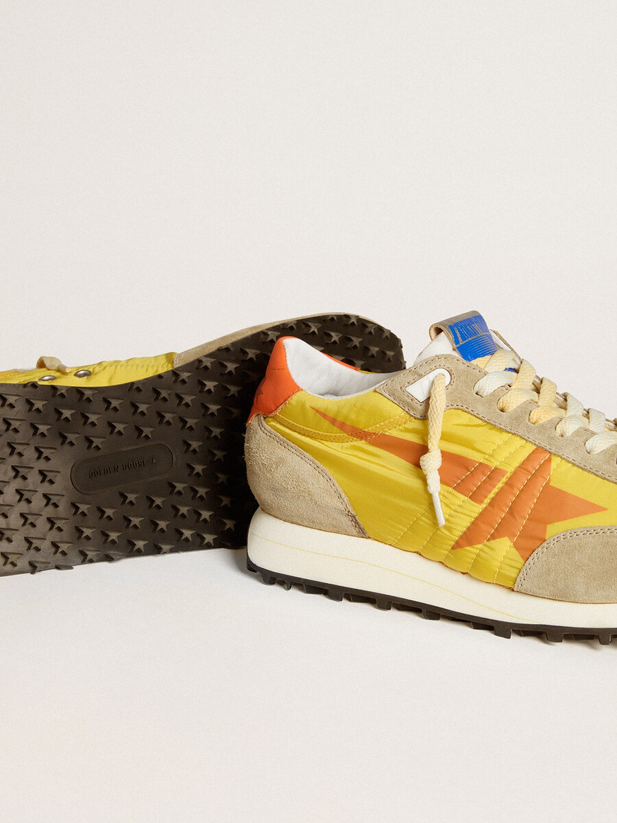 herren-marathonschuh mit gelbem nylon-obermaterial und orangefarbenem stern