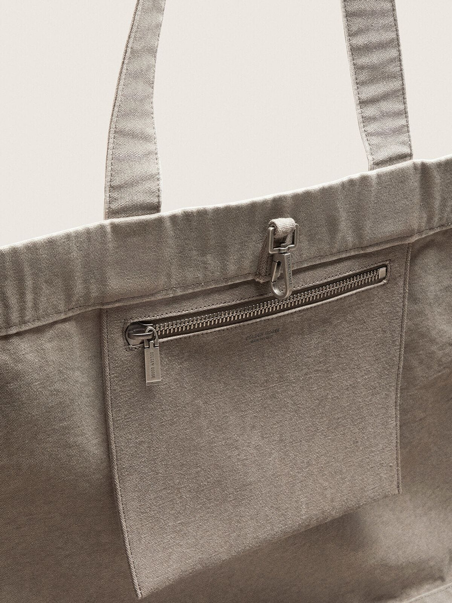 anthrazitfarbene tragetasche aus canvas mit stickereien und details in antiksilber.