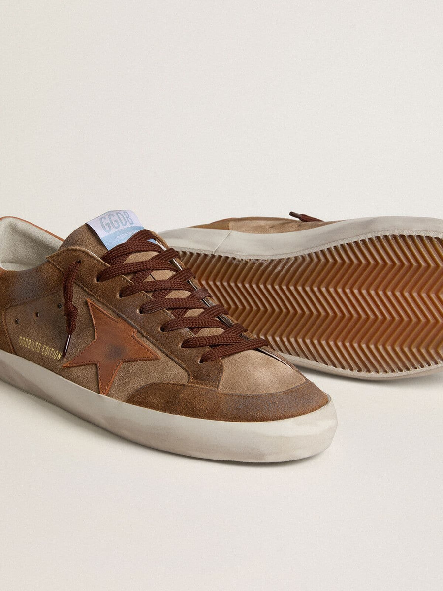 herren-super-star aus braunem wildleder mit hellbraunem lederstern und fersenlasche.