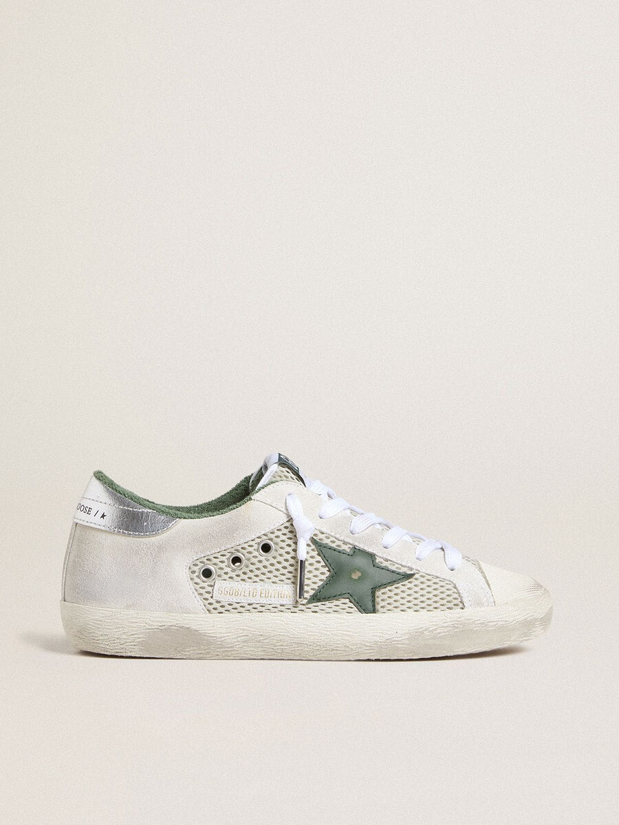 super-star ltd damenschuh aus weißem wildleder und mesh mit grünem lederstern und silberfarbener fersenlasche aus leder mit folienprägung.