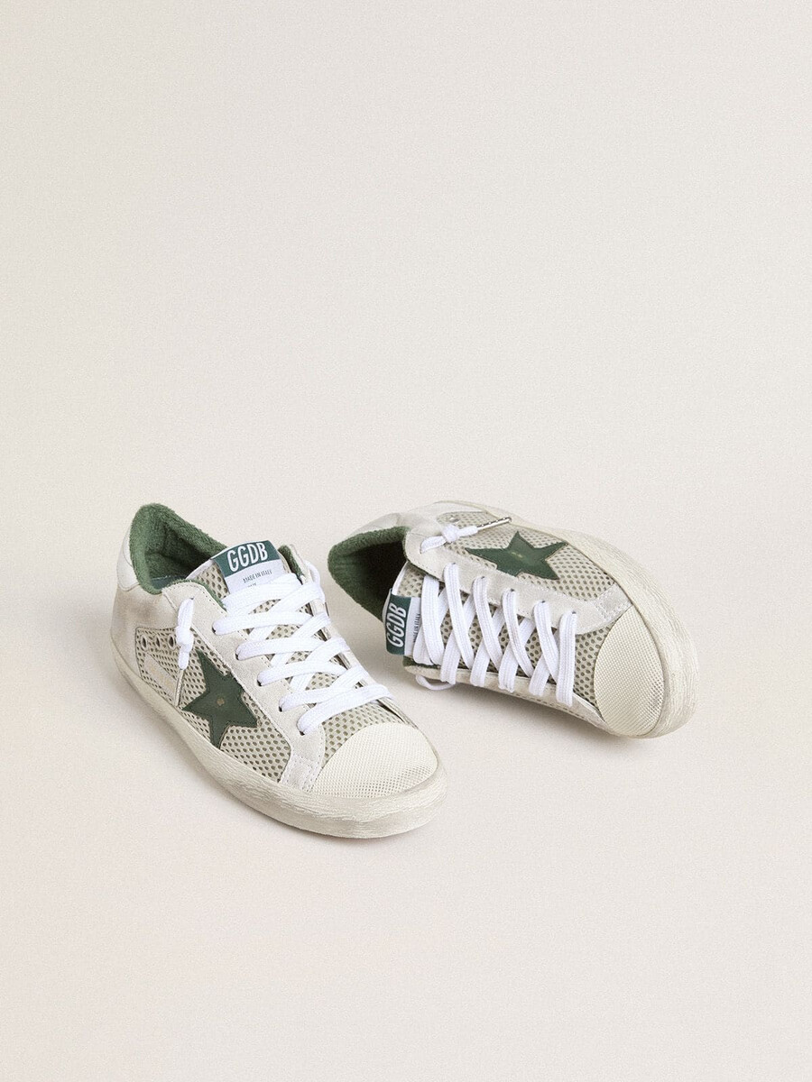 super-star ltd damenschuh aus weißem wildleder und mesh mit grünem lederstern und silberfarbener fersenlasche aus leder mit folienprägung.