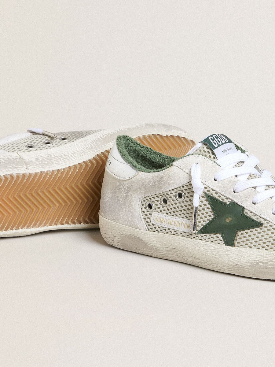 super-star ltd damenschuh aus weißem wildleder und mesh mit grünem lederstern und silberfarbener fersenlasche aus leder mit folienprägung.