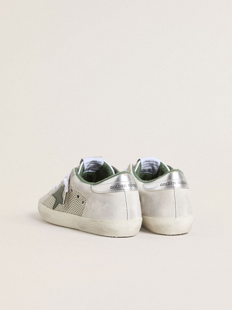 super-star ltd damenschuh aus weißem wildleder und mesh mit grünem lederstern und silberfarbener fersenlasche aus leder mit folienprägung.