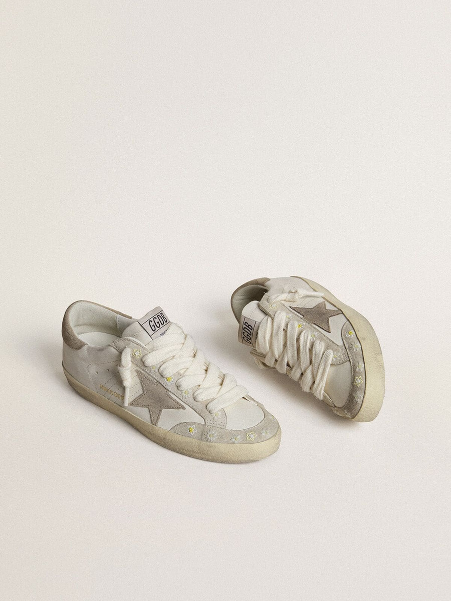 super-star ltd damenschuh mit beigefarbenem wildlederstern und fersenlasche sowie floraler stickerei