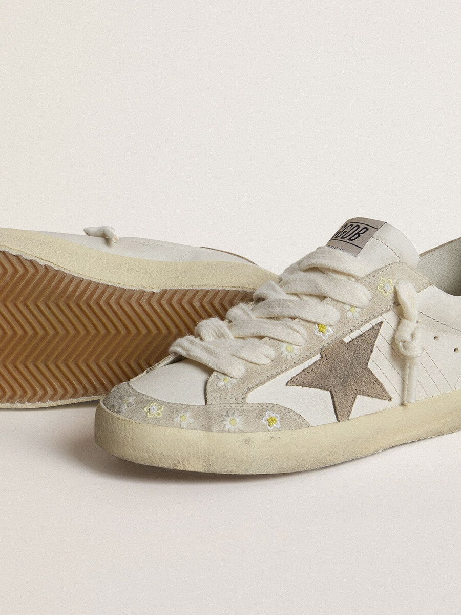 super-star ltd damenschuh mit beigefarbenem wildlederstern und fersenlasche sowie floraler stickerei