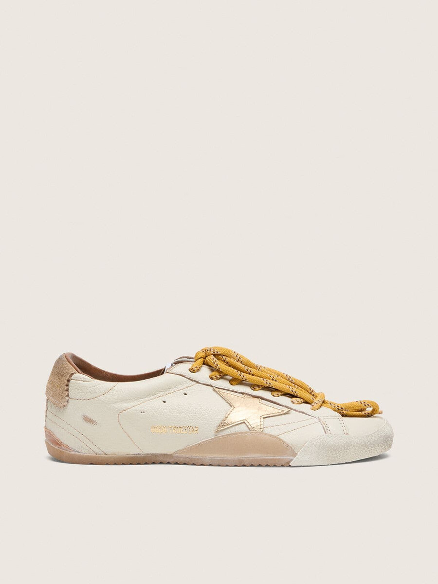 herren-sneaker true-star aus weißem nappaleder mit goldfoliengeprägtem lederstern und beigefarbener wildleder-fersenlasche.