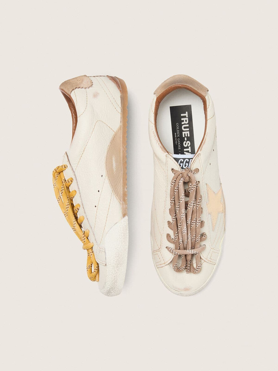 herren-sneaker true-star aus weißem nappaleder mit goldfoliengeprägtem lederstern und beigefarbener wildleder-fersenlasche.