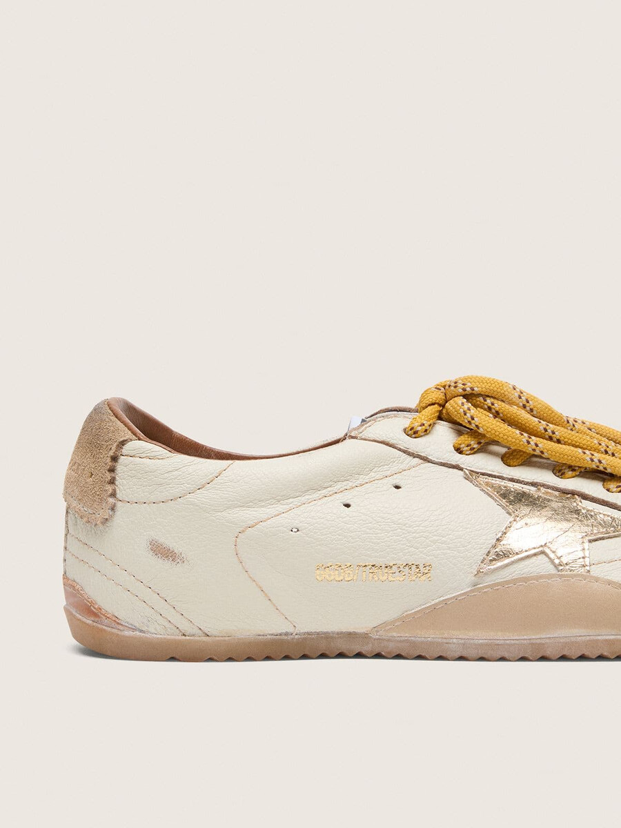 herren-sneaker true-star aus weißem nappaleder mit goldfoliengeprägtem lederstern und beigefarbener wildleder-fersenlasche.