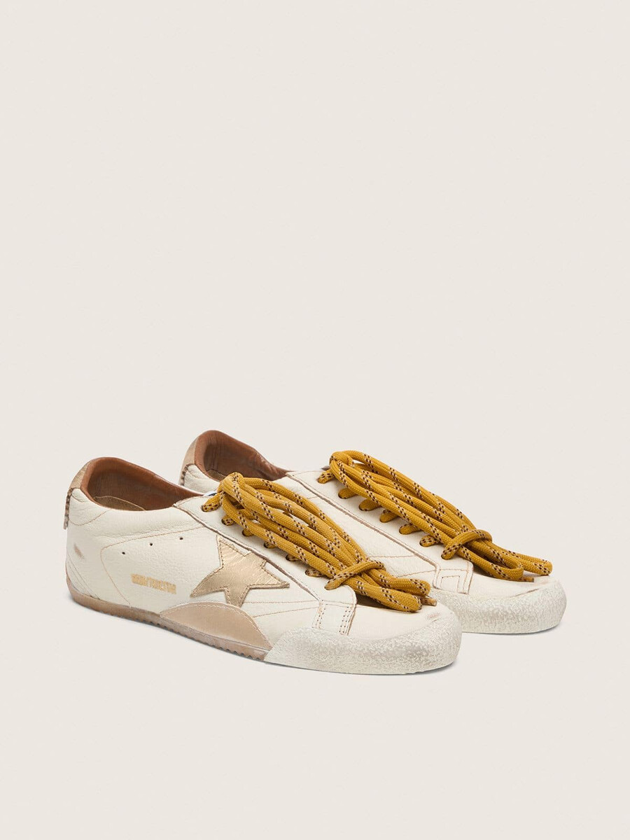 herren-sneaker true-star aus weißem nappaleder mit goldfoliengeprägtem lederstern und beigefarbener wildleder-fersenlasche.