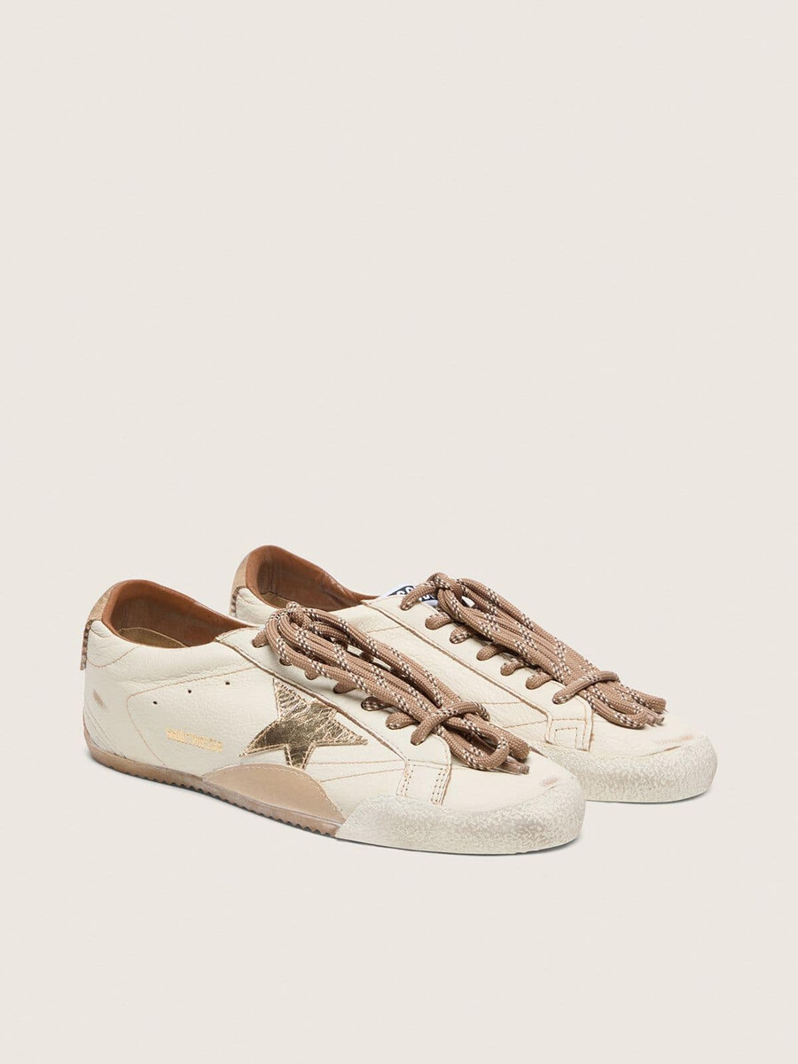 herren-sneaker true-star aus weißem nappaleder mit goldfoliengeprägtem lederstern und beigefarbener wildleder-fersenlasche.