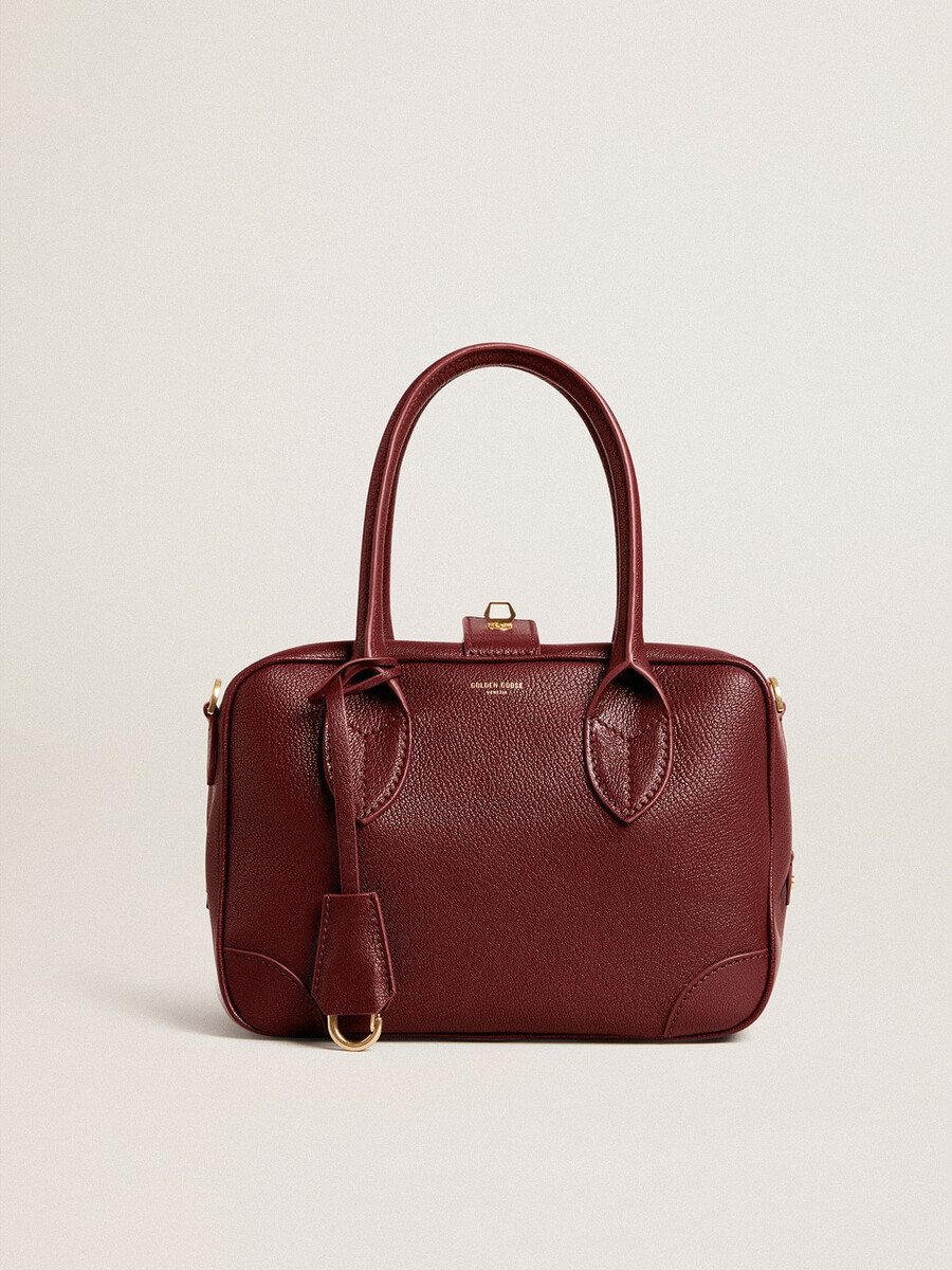 vita-tasche aus burgunderrotem leder mit goldenen details