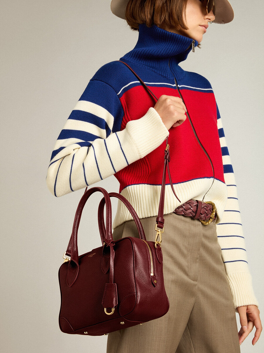 vita-tasche aus burgunderrotem leder mit goldenen details